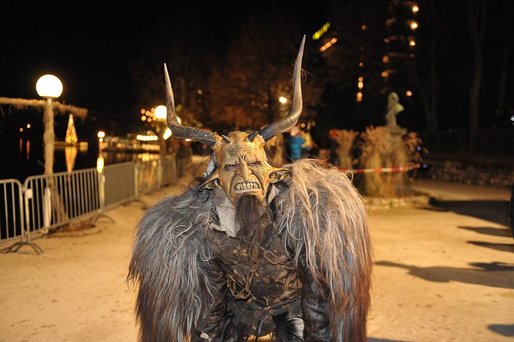 Person in a horned Krampus mask and fur costume at the Pörtschach Krampuslauf at night